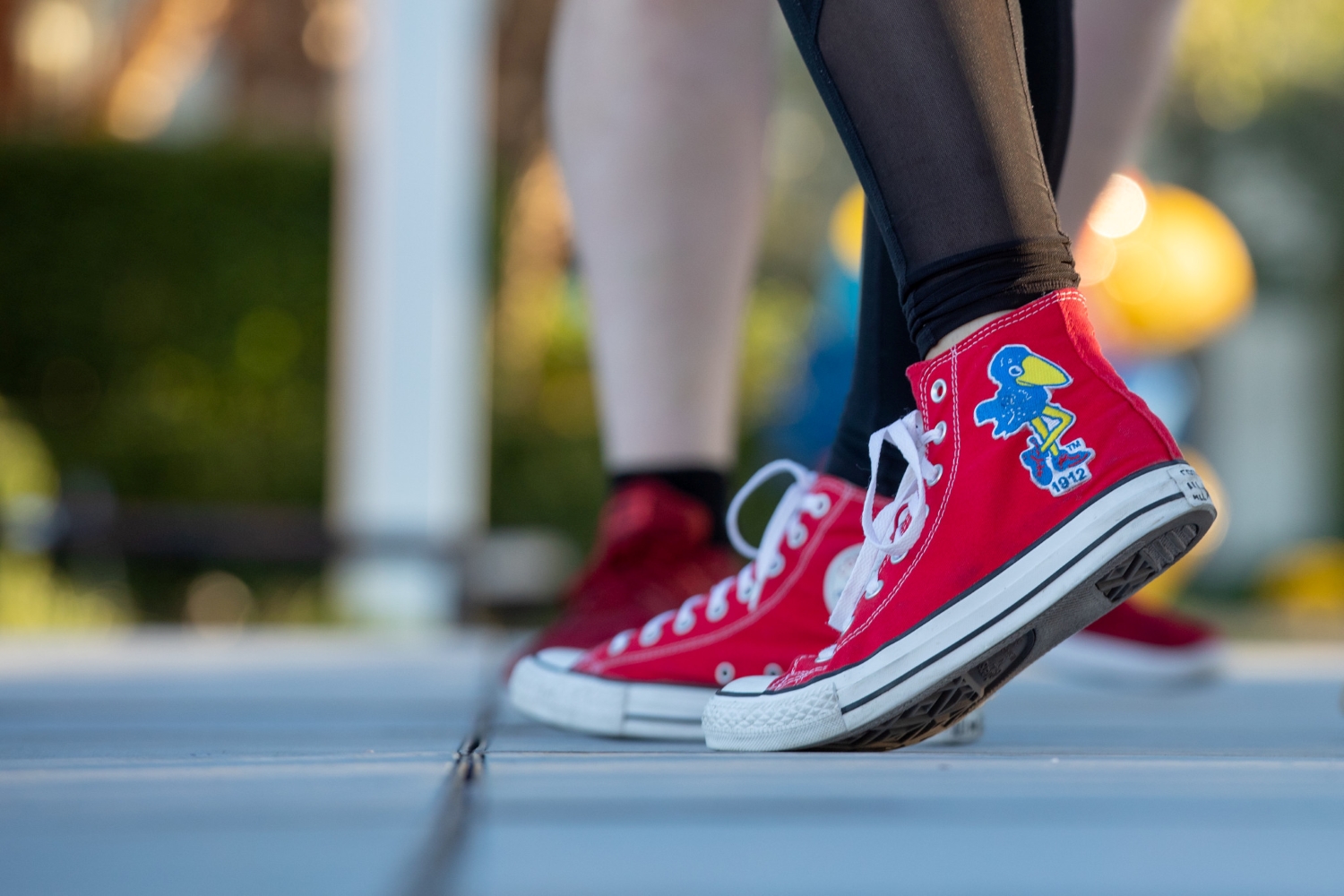 Pair of red shoes with a Jayhawk
