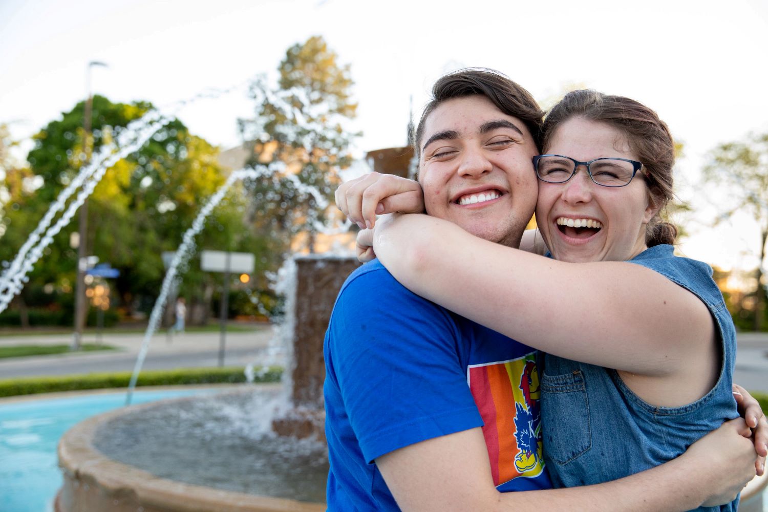 Two students hugging in a fountain