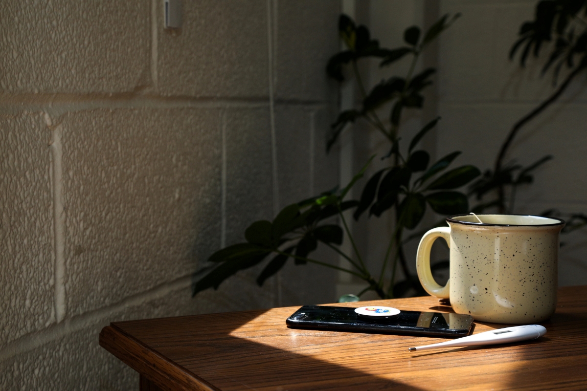 table with mug, thermometer, and cell phone