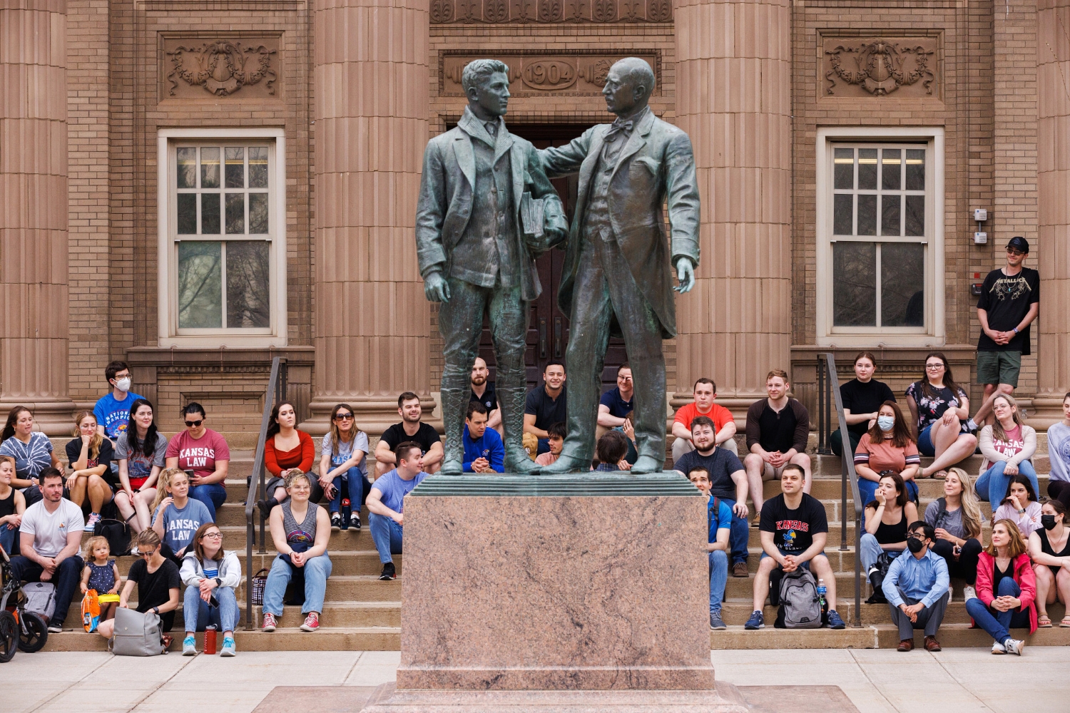 Students sitting behind statue