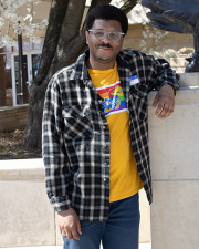 Photo of Cornelius Baker posing next to statue of Jayhawk outisde